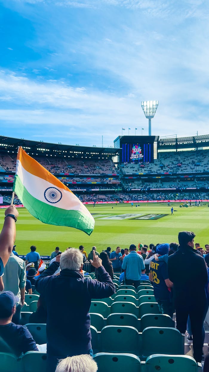 our-mission Excited fans waving the Indian flag at Melbourne Cricket Ground during a cricket match.